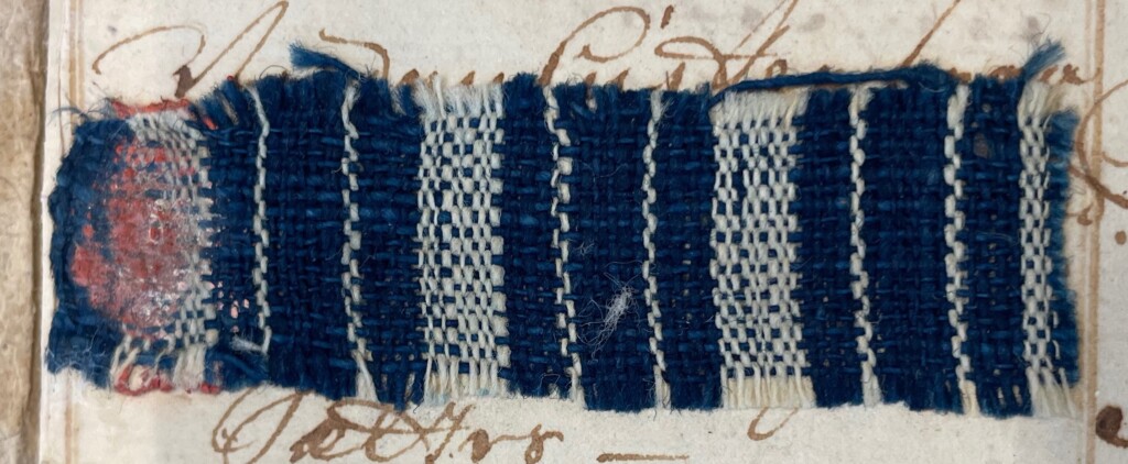 blue woven cloth with vertical alternating thin and thick white stripes