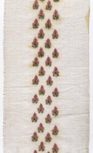 colorful repeating small floral design embroidered on white cloth