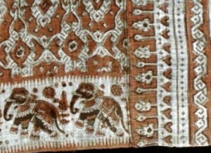 White cloth printed with geometric motifs and an elephant border.